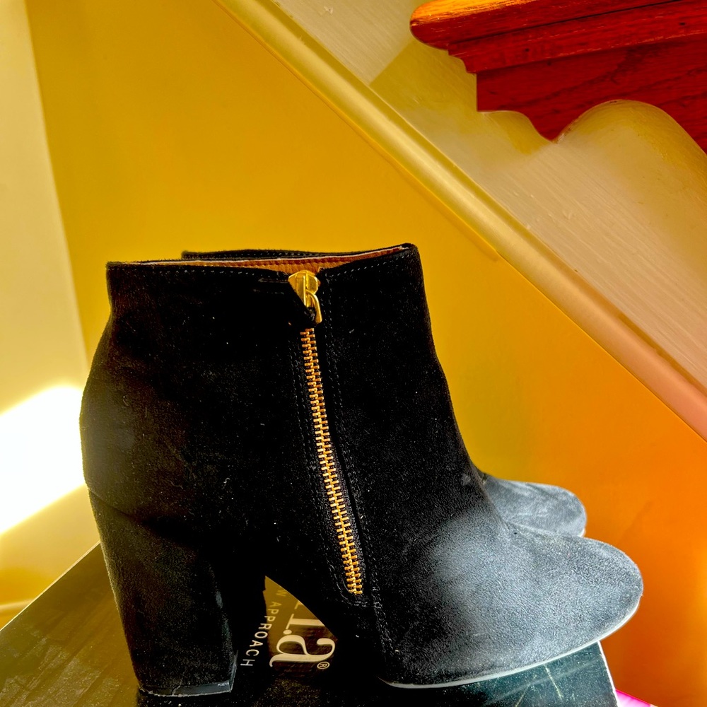 Black suede boots with golden zipper.